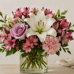Pink and white bouquet with a lily and rose in a glass vase