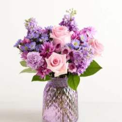 Pink and purple mixed bouquet in a textured glass vase