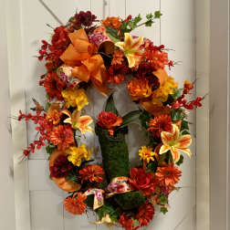 Autumn wreath with orange and red flowers on a white door