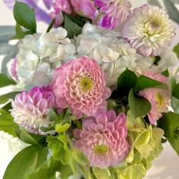 Pink and white flowers arranged with green foliage