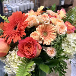 Large bouquet of peach and coral roses with orange gerbera daisies