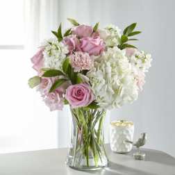 Pink roses and white hydrangeas in a clear glass vase