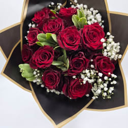 Bouquet of red roses with white baby's breath in black and gold wrap