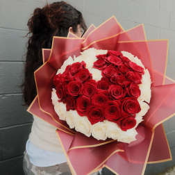Large bouquet of red and white roses wrapped in pink paper