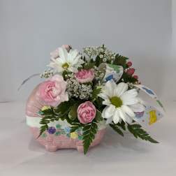 Pink and white flowers arranged in a pink basket-shaped container