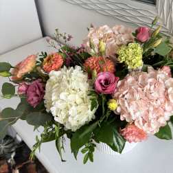 Mixed pink and white floral arrangement in a white vase