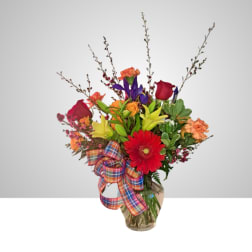 Mixed bouquet with roses, lilies, gerbera daisies, and carnations in a glass vase