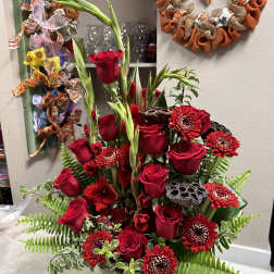 Tall arrangement of red roses and red chrysanthemums in a vase
