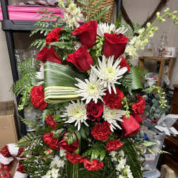 Red roses and white daisies arranged in a standing spray