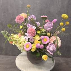 Mixed pastel flower arrangement in a dark vase
