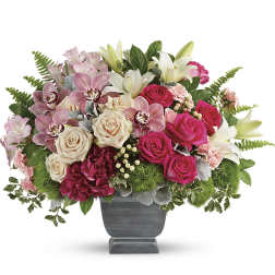 Pink and cream roses with lilies in a gray pedestal vase