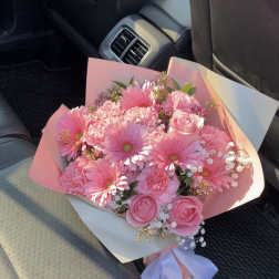 Pink bouquet with gerbera daisies and roses wrapped in pastel paper