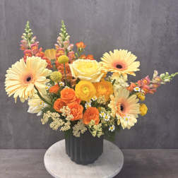 Colorful mixed bouquet in a dark vase with gerberas and roses