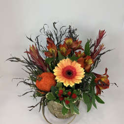 Orange and red floral arrangement in a basket with a large gerbera daisy
