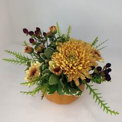 Yellow chrysanthemum arrangement in a round orange container