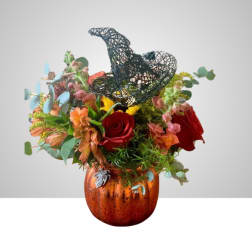 Mixed bouquet in an orange pumpkin vase with a black witch hat topper