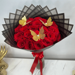 Bouquet of red roses wrapped in black paper with gold butterfly accents
