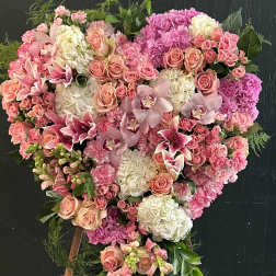 Heart-shaped floral standing arrangement in pink, peach, and white blooms