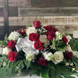 Red and white rose arrangement with a white ribbon bow