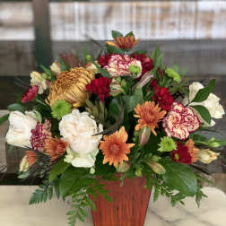 Mixed bouquet of chrysanthemums and carnations in a wooden vase