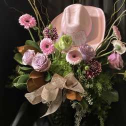 Pink and lavender bouquet with a pink cowboy hat and glittery ribbon