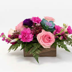Pink and purple floral arrangement in a wooden box