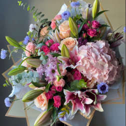 Large bouquet of pink lilies, roses, hydrangea, and blue accent flowers