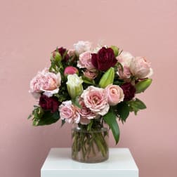 Bouquet of pink and burgundy roses in a clear glass vase