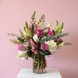 Pink and white floral arrangement in a glass vase