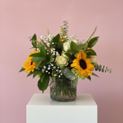 Sunflower and white rose arrangement in a glass vase