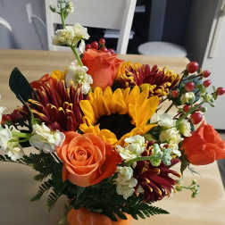 Orange and yellow bouquet in a pumpkin-shaped vase