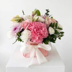 Pink and white mixed flower arrangement in a pink box with a white ribbon