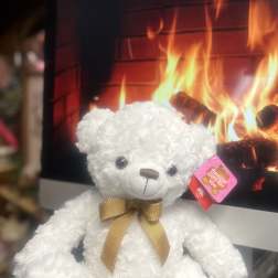 White teddy bear with a gold ribbon bow