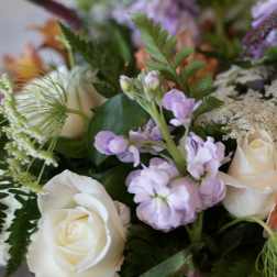 Bouquet of white roses and lavender flowers with mixed greenery