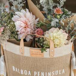 Two pastel flower bouquets in a burlap tote bag