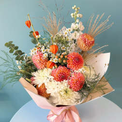 Mixed bouquet of pink, white, and orange flowers with a pink ribbon wrap