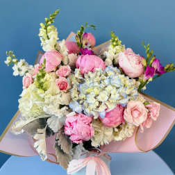Pastel bouquet of pink peonies, hydrangeas, and roses with ribbon wrap