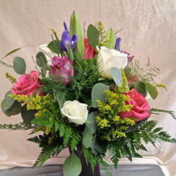 Elegant arrangement with mixed colored roses and greenery