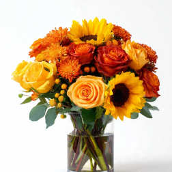 Bouquet of yellow and orange flowers in a clear glass vase