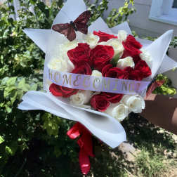 Bouquet of red and white roses wrapped in white paper with a butterfly decoration