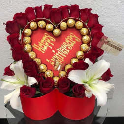 Heart-shaped rose arrangement with chocolates and white lilies