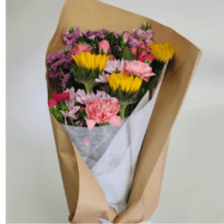 Bouquet of pink, purple, and yellow flowers wrapped in brown paper
