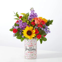 Mixed bouquet in a birthday vase with sunflower, roses, and purple flowers