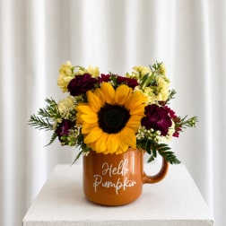 Sunflower arrangement in an orange mug with "Hello Pumpkin" text