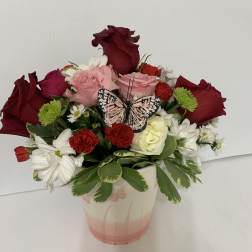 Mixed bouquet in a pink vase with a butterfly decoration