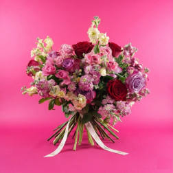Bouquet of pink, red, and lavender roses with small filler flowers
