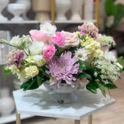 Pastel flower arrangement in a pedestal vase with pink, white, and lavender blooms