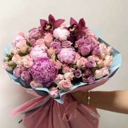 Pink and lavender bouquet with roses and orchids wrapped in paper