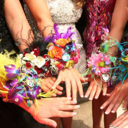Colorful floral wrist corsages worn by several people