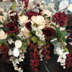 Large arrangement of red and white roses with cascading white orchids